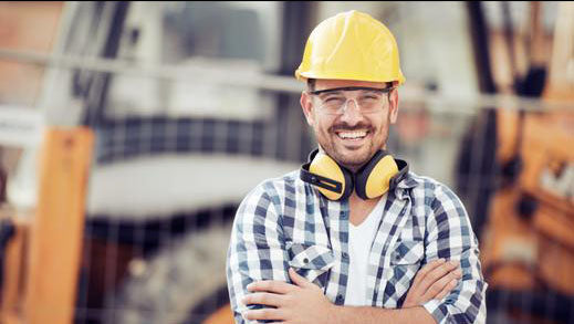 Construction worker wearing hard hat and ear protection.